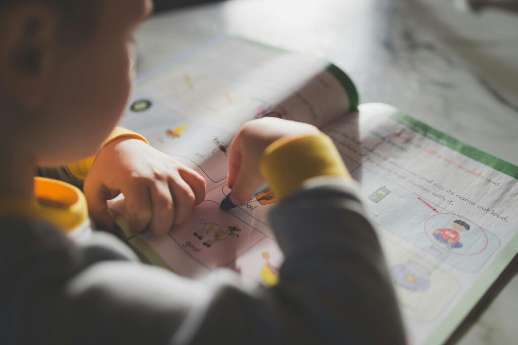 Young toddler coloring in a workbook, illustrating focus on early childhood education.