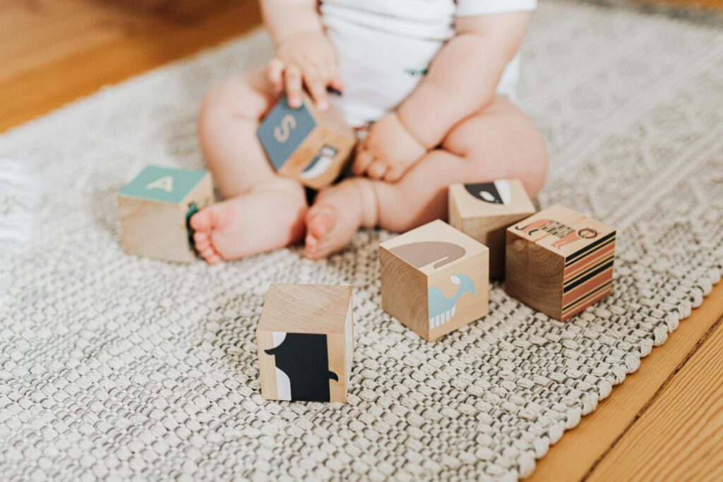 Baby playing with colorful wooden blocks, one of the best educational toys for toddlers