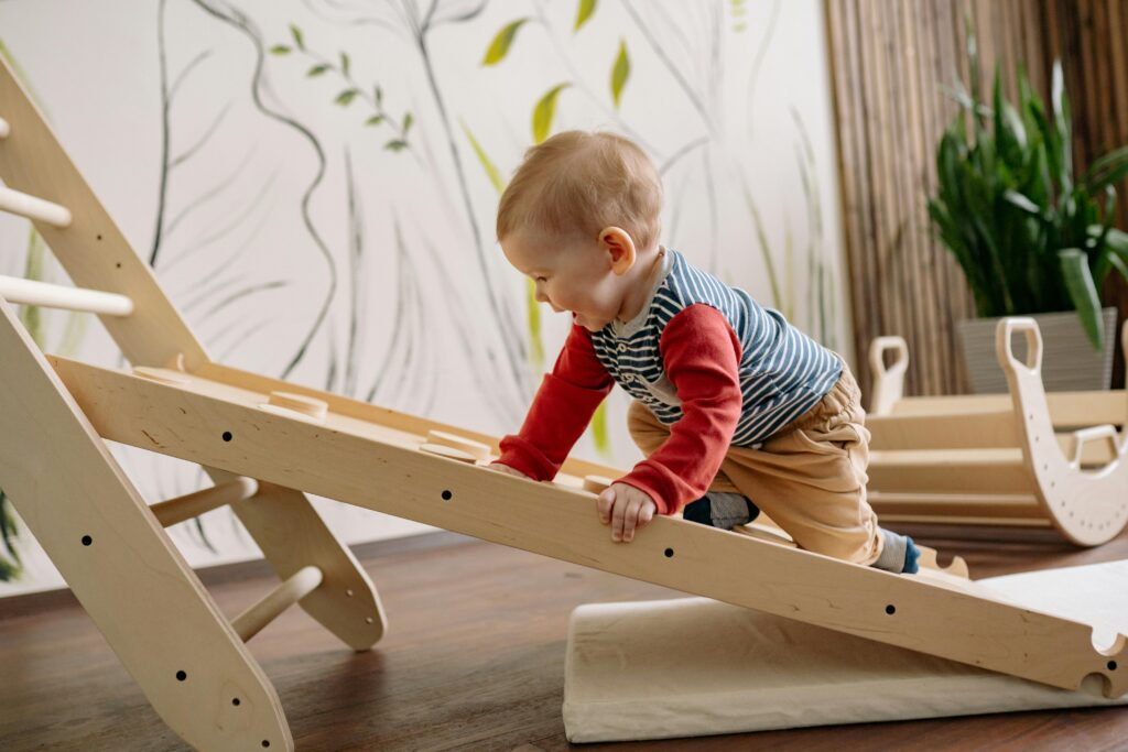 A young child enjoys climbing a wooden toy ladder indoors, promoting playtime and fun toddler activity for toddler development.