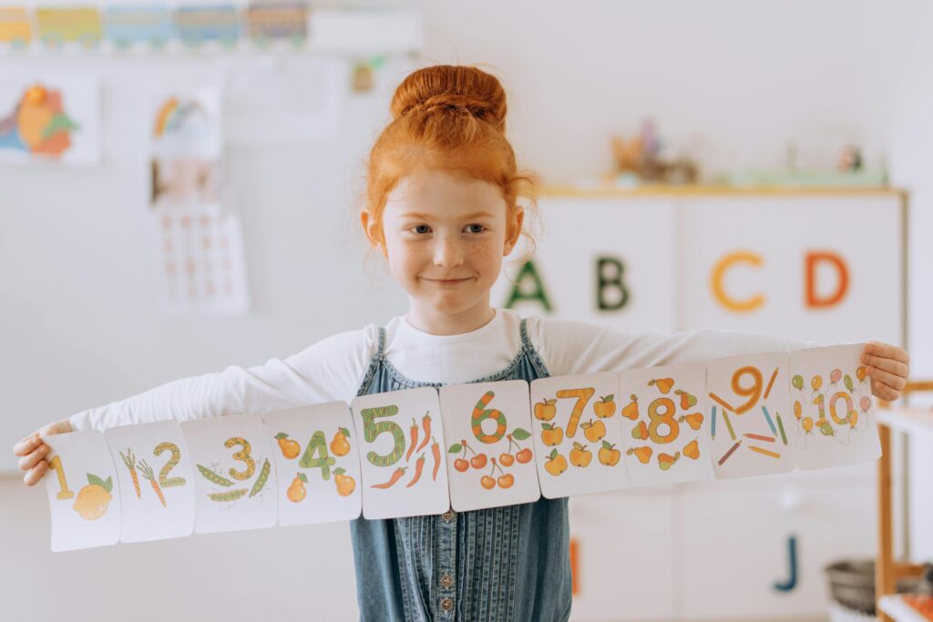 Young girl learning numbers through a counting game for toddlers in a colorful classroom